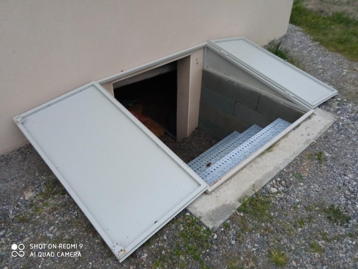 Accès sous-sol en métal avec escalier sécurisé et solide