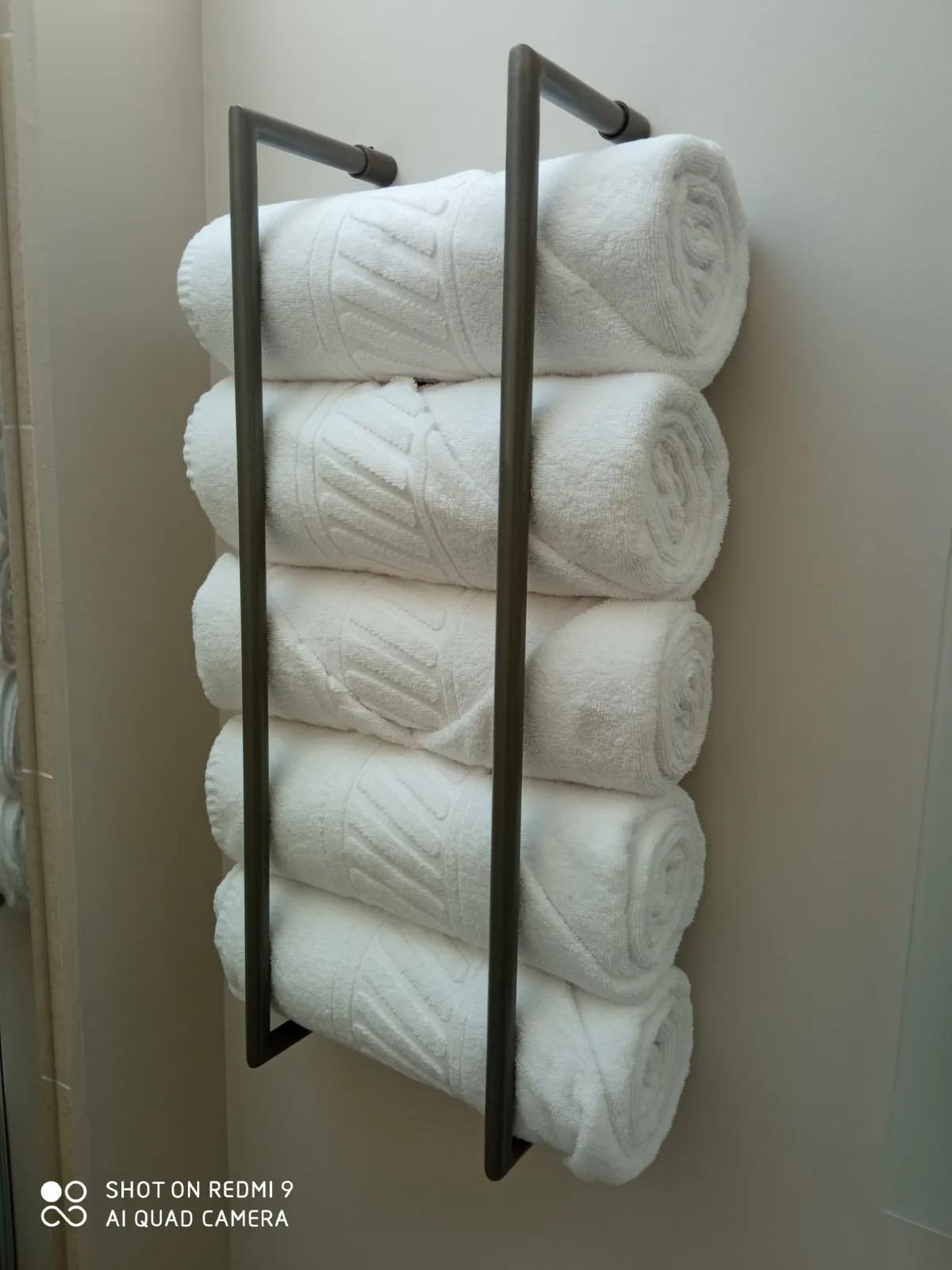 Serviette enroulée dans un porte-serviette métallique moderne.